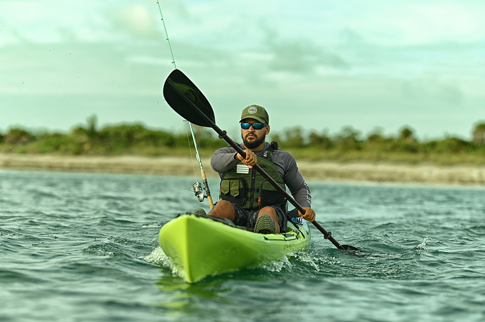 Man in sit-on-top Ocean Kayak Malibu kayak paddling with fishing rod ready