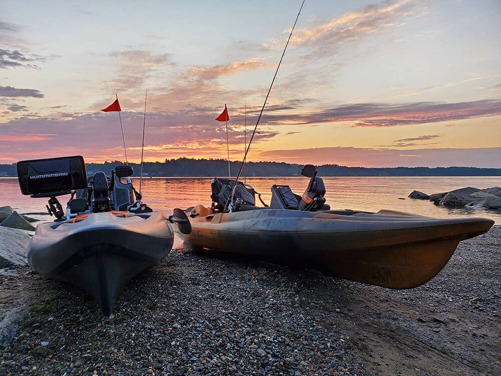 Sunrise picture of two Old Town pedal kayaks resting at the boat launch. 