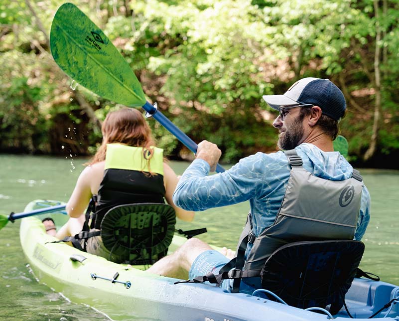 Couple paddling in the Old Town Ocean Kayak Malibu Two kayak wearing Riverstream Life Jackets