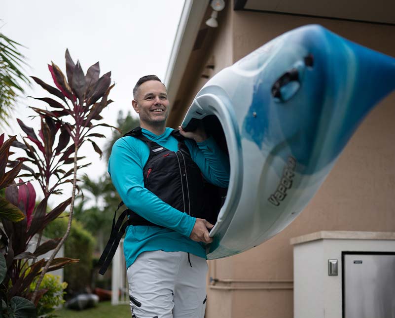 Man carrying the Old Town Vapor kayak