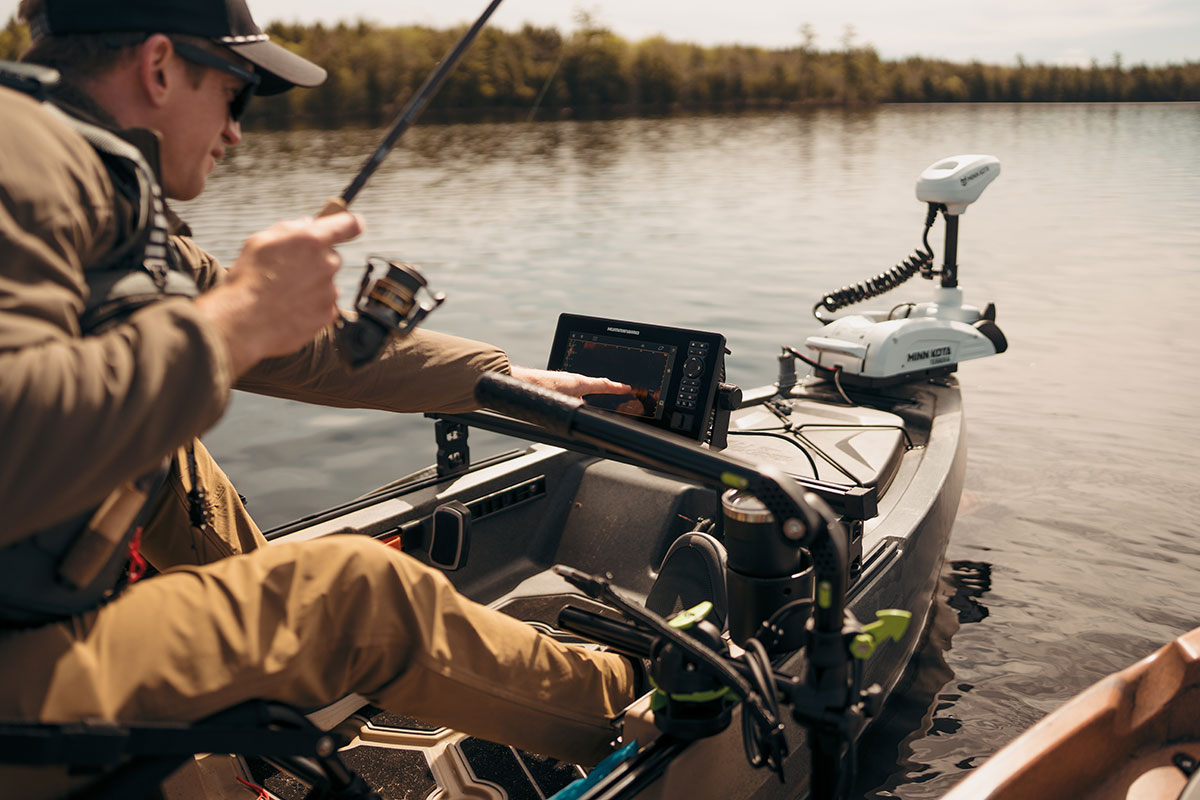 Tapping on Humminbird fish finder while fishing from the Old Town Sportsman 120 PRO fishing kayak on the water