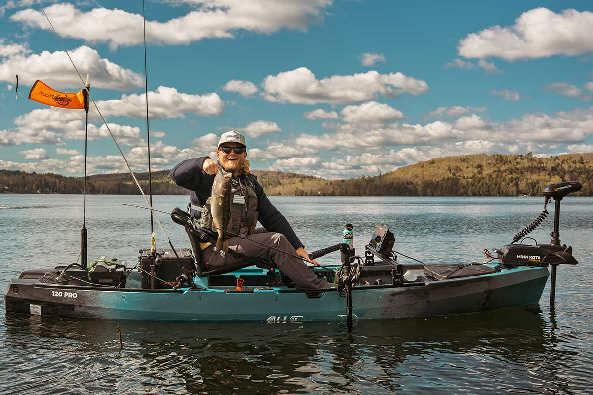 Angler holding up caught fish in the Old Town Sportsman 120 PRO Fishing Kayak
