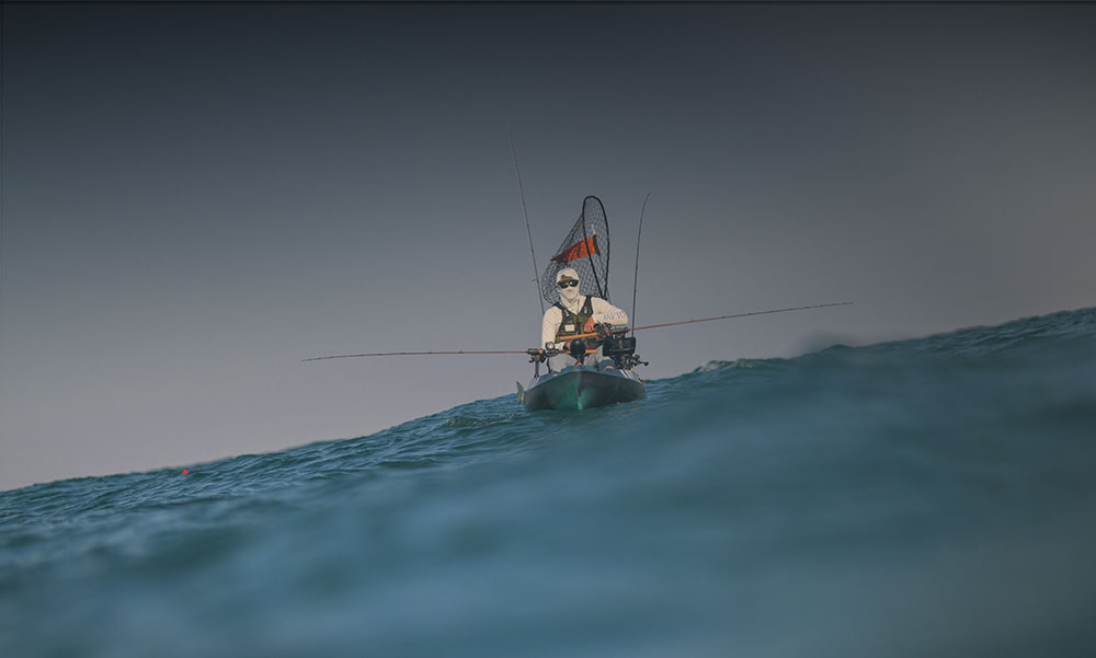 Man in Old Town sportsman kayak on wavy water