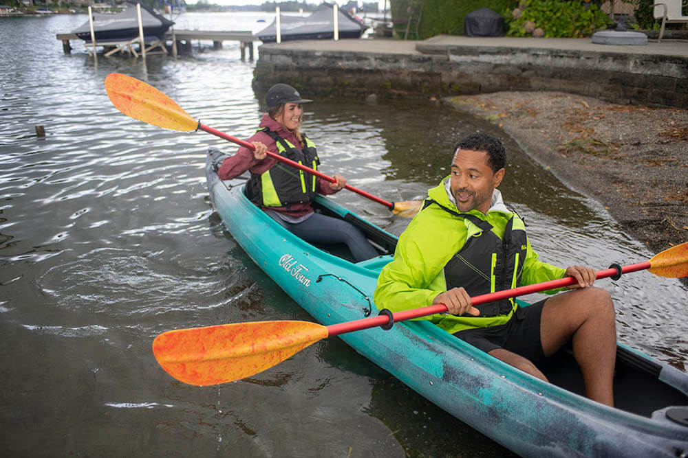 Happy man and woman paddling in Tandem Old town Dirigo Plus Kayak