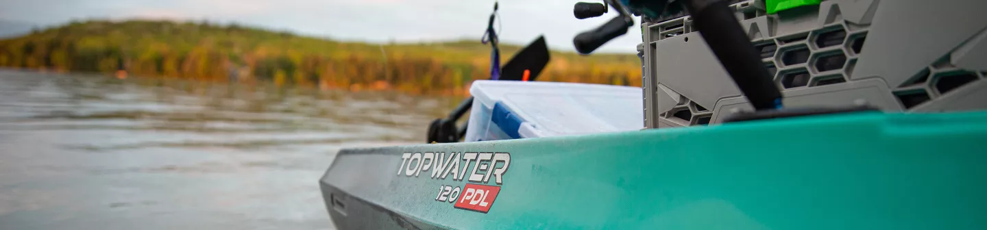 Closeup of kayak hull with tackle boxes and gear crate