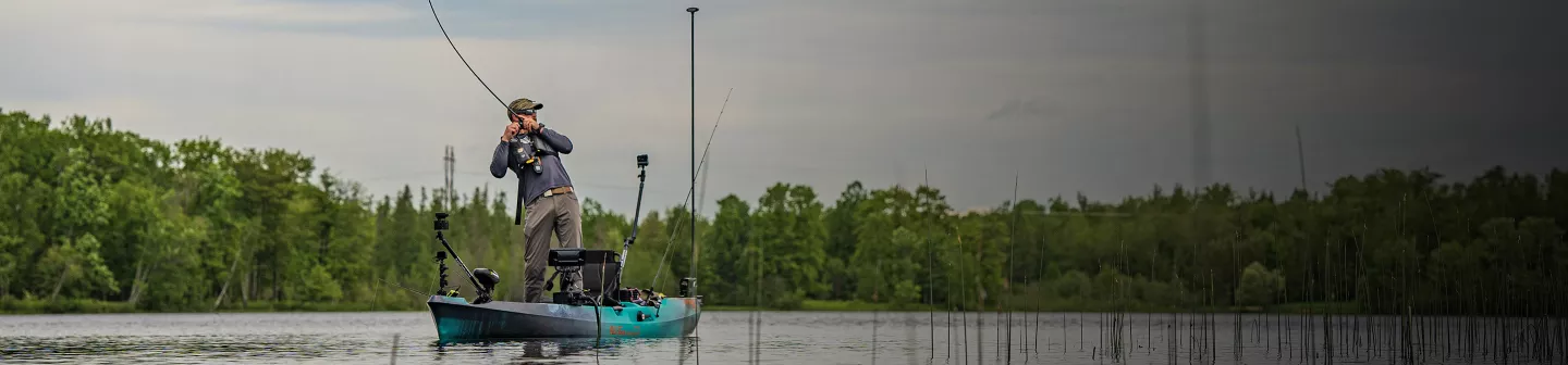 A kayak angler stands and sets the hook on an AutoPilot.