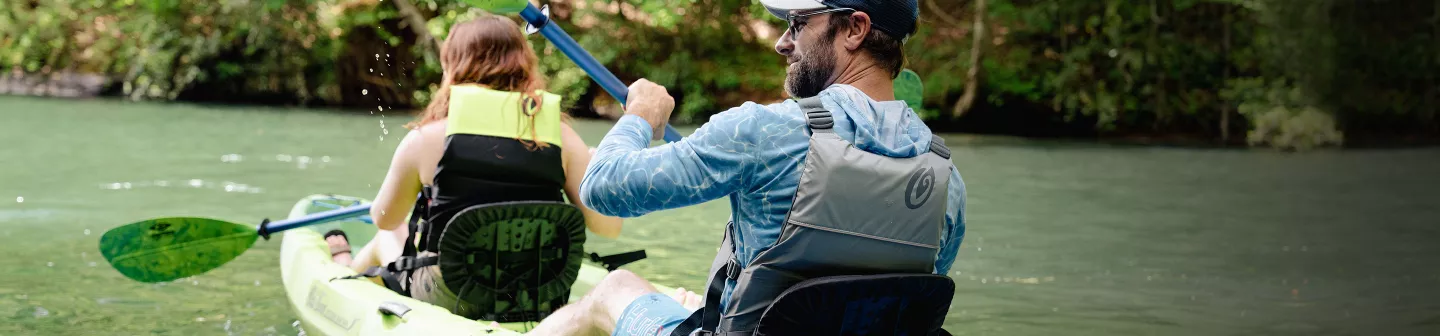 Two people wearing Old Town Life Jackets paddling in Ocean Kayak kayak