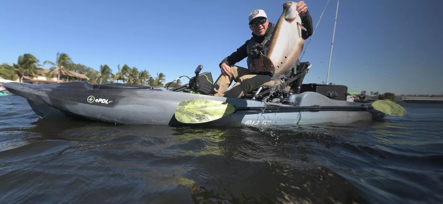 Holding a large fish caught in the Old Town Sportsman BigWater 132 ePDL+ fishing kayak