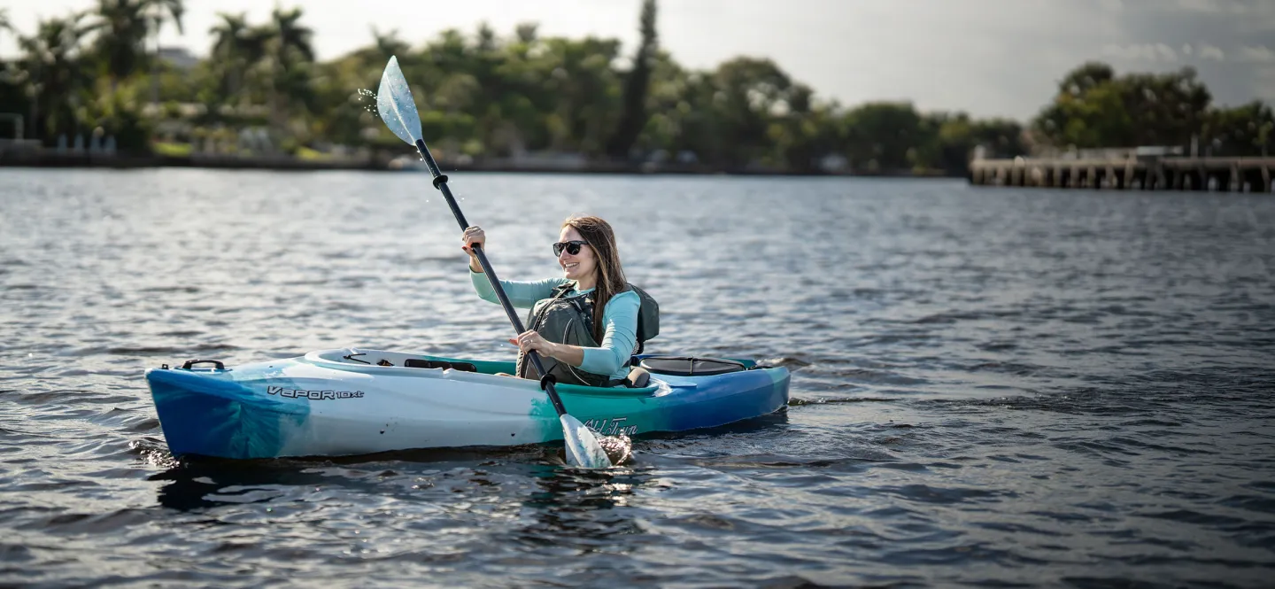 Woman happily paddling in Old Town Vapor 12XT recreational kayak