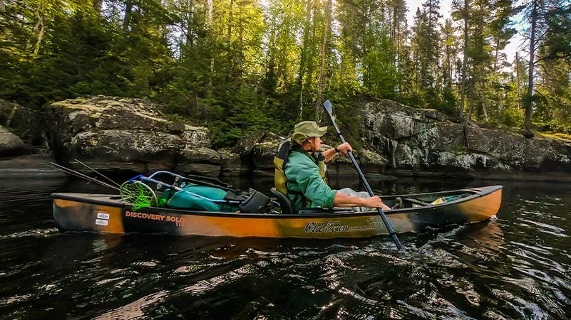 Man paddling in Old Town Sportsman Solo 119 canoe ready for a fishing trip