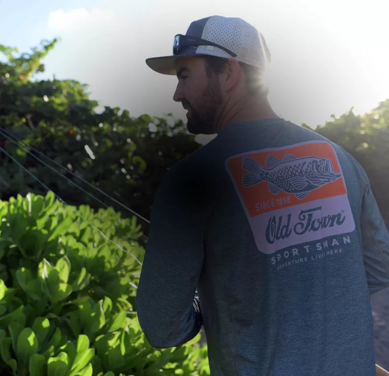 A man wearing an Old Town Sportsman fishing shirt