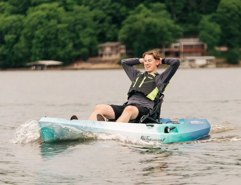 Man relaxing with arms up cruising on the water in the Old Town Ocean Kayak Sonata 106MK