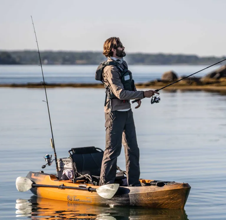 Man standing up and fishing from the Old Town Sportsman 106 Powered by Minn Kota Fishing kayak