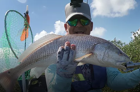 Kaan Orer holds up a large red drum fish.