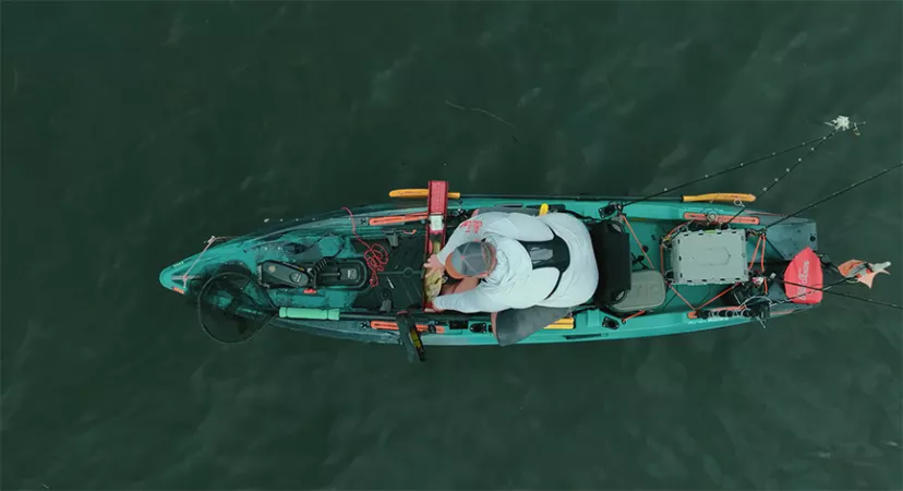 A kayak angler measures a bass on a Ketch board.